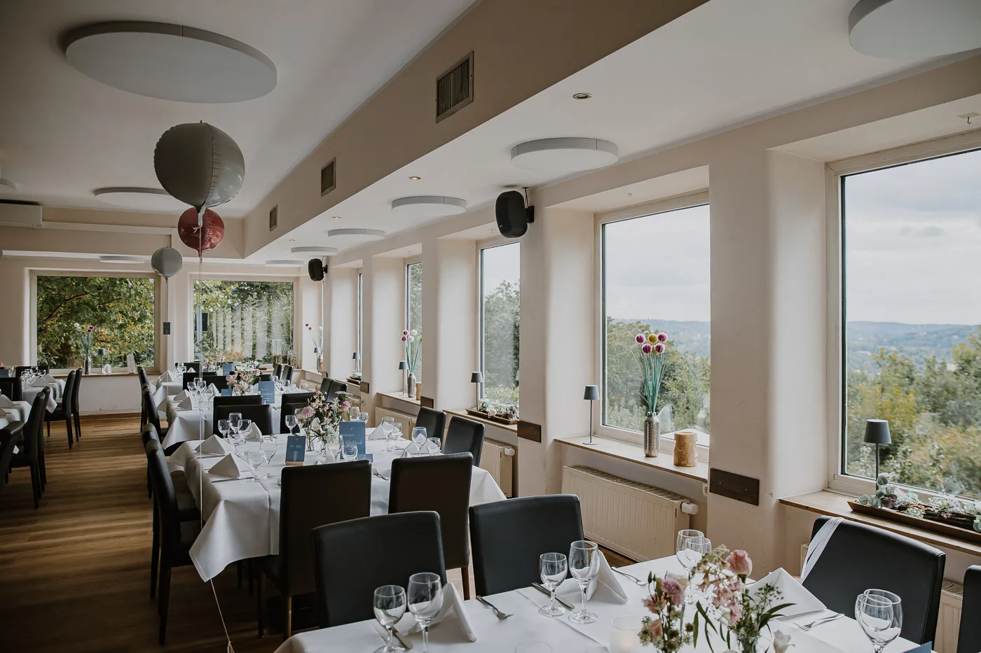 Elegant eingedeckte Festtafel mit Sonnenblumen und Panoramablick auf den Baldeneysee